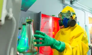 Engenheira química com máscara de proteção respiratória no laboratório químico.
