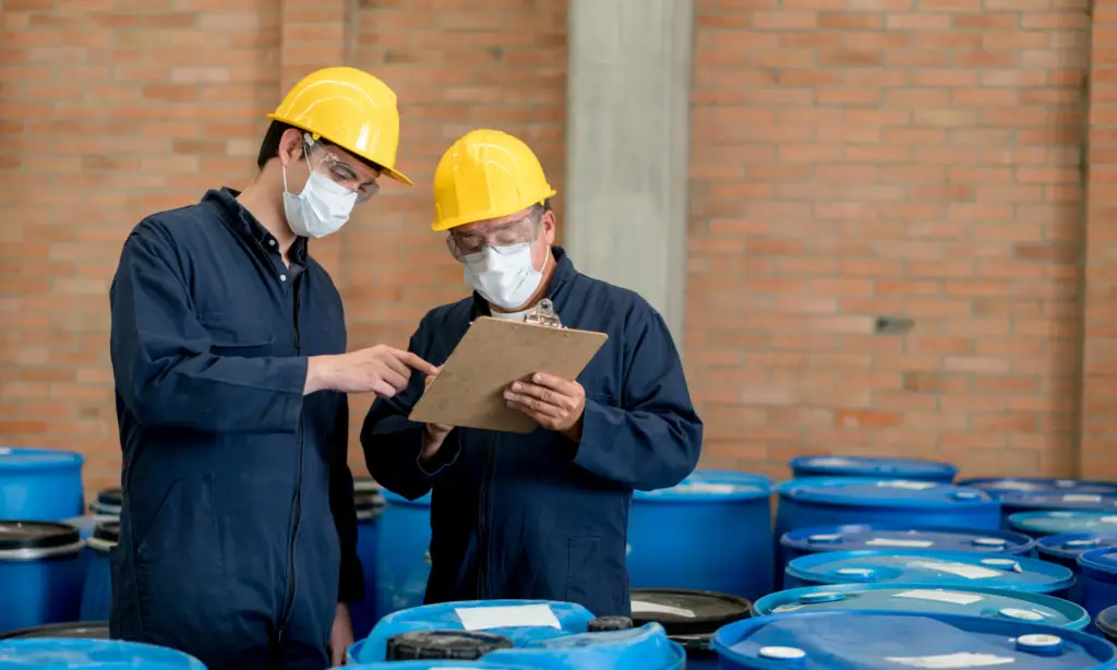 Trabalhadores conferindo a atualização da FISPQ no estoque de produtos químicos