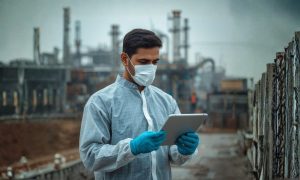 Funcionario com tablet avaliando conformidade da SDS após o OSHA estender prazos do HazCom 2024