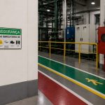 Corredor industrial com sinalização de segurança para nr 26